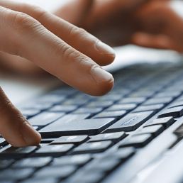 Nahaufnahme einer Tastatur mit einem Händepaar